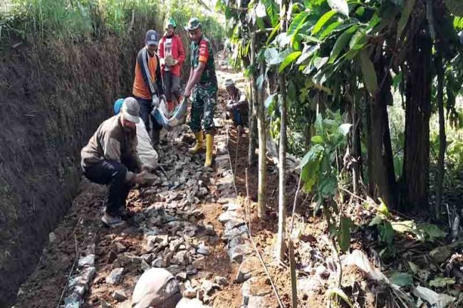 Babinsa Koramil 04/Karangkobar Bersama Warga Kerja Bakti Pembangunan Makadam Jalan Usaha Tani