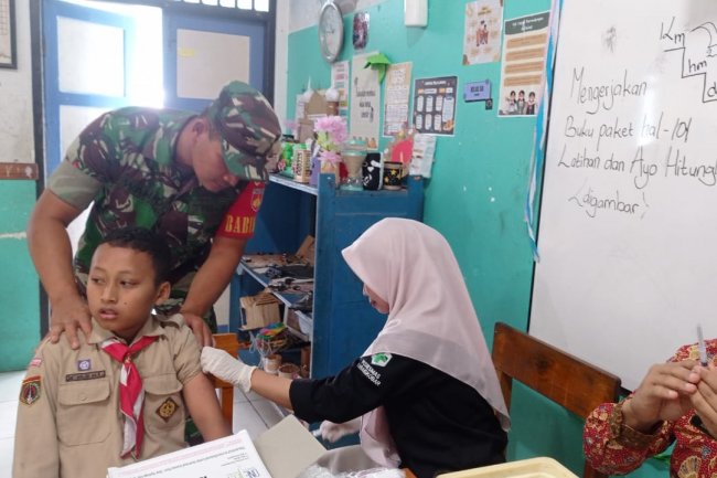 Babinsa Dampingi Petugas Puskesmas Sukseskan Bulan Imunisasi Anak Sekolah