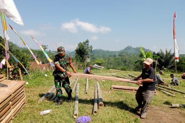 Membaur Dengan Warga Babinsa Serka Purnomo Bantu Pemasangan Panggung Hiburan Desa Binaan