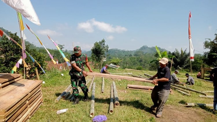 Membaur Dengan Warga Babinsa Serka Purnomo Bantu Pemasangan Panggung Hiburan Desa Binaan