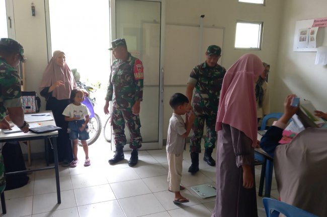 Babinsa Koramil 04/Karangkobar Bantu Bidan Desa Dampingi Giat Posyandu Balita