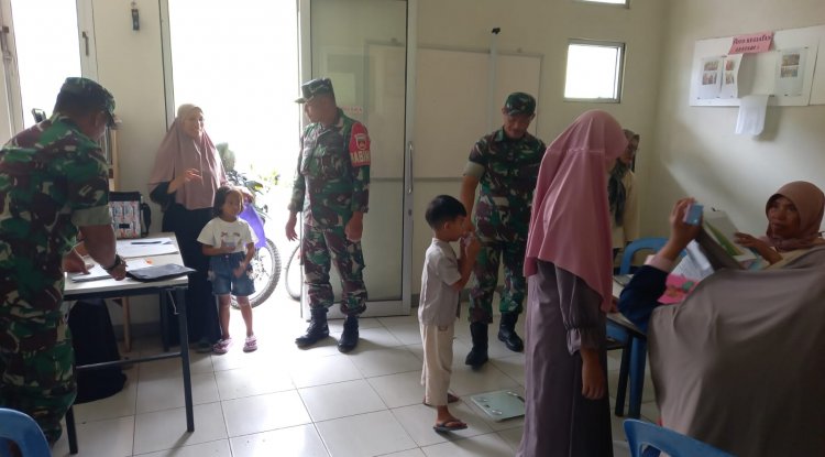 Babinsa Koramil 04/Karangkobar Bantu Bidan Desa Dampingi Giat Posyandu Balita